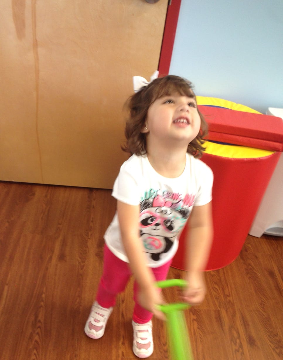 Girl pulling a toy smiling